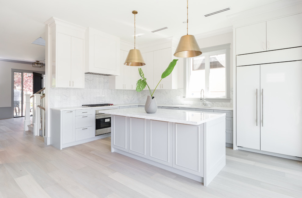Photo of a medium sized classic l-shaped open plan kitchen in Vancouver with a single-bowl sink, shaker cabinets, white cabinets, marble worktops, white splashback, marble splashback, integrated appliances, light hardwood flooring and an island.