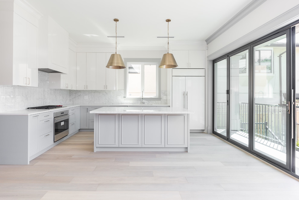 Photo of a medium sized classic l-shaped open plan kitchen in Vancouver with a single-bowl sink, shaker cabinets, white cabinets, marble worktops, white splashback, marble splashback, integrated appliances, light hardwood flooring and an island.