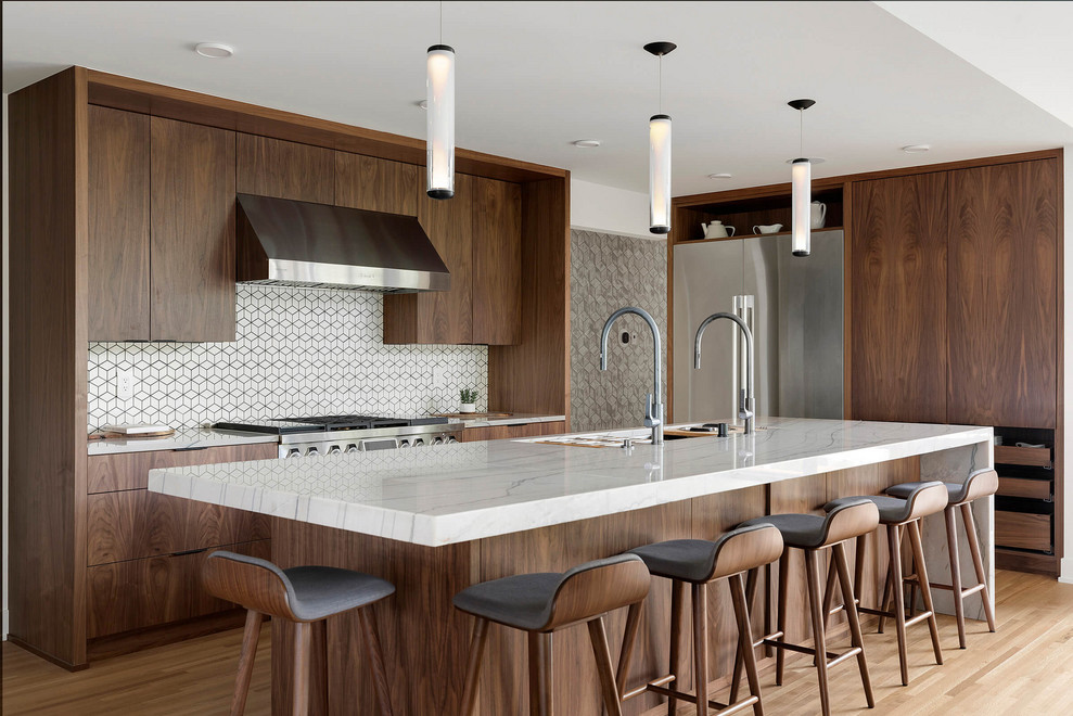 Modern inredning av ett vit vitt kök, med en undermonterad diskho, släta luckor, skåp i mörkt trä, vitt stänkskydd, rostfria vitvaror, ljust trägolv, en köksö och beiget golv