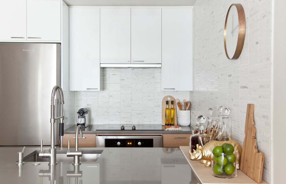 Eat-in kitchen - small transitional galley ceramic tile eat-in kitchen idea in Vancouver with an undermount sink, flat-panel cabinets, light wood cabinets, quartz countertops, white backsplash, stone tile backsplash, stainless steel appliances and an island