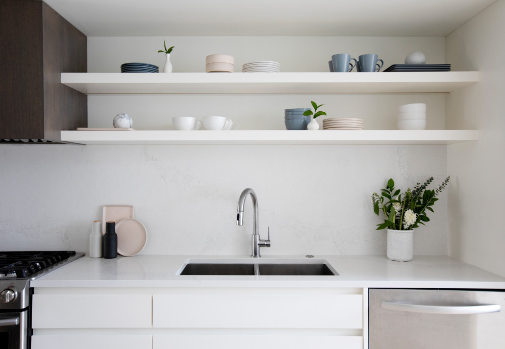 Foto di una cucina minimalista di medie dimensioni con lavello a doppia vasca, ante bianche, top in quarzo composito e paraspruzzi in quarzo composito