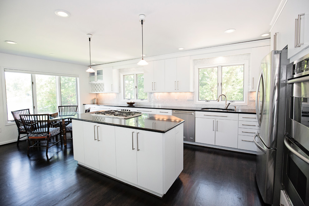 Large traditional l-shaped kitchen/diner in Baltimore with a submerged sink, flat-panel cabinets, white cabinets, granite worktops, grey splashback, marble splashback, stainless steel appliances, dark hardwood flooring, an island and black floors.