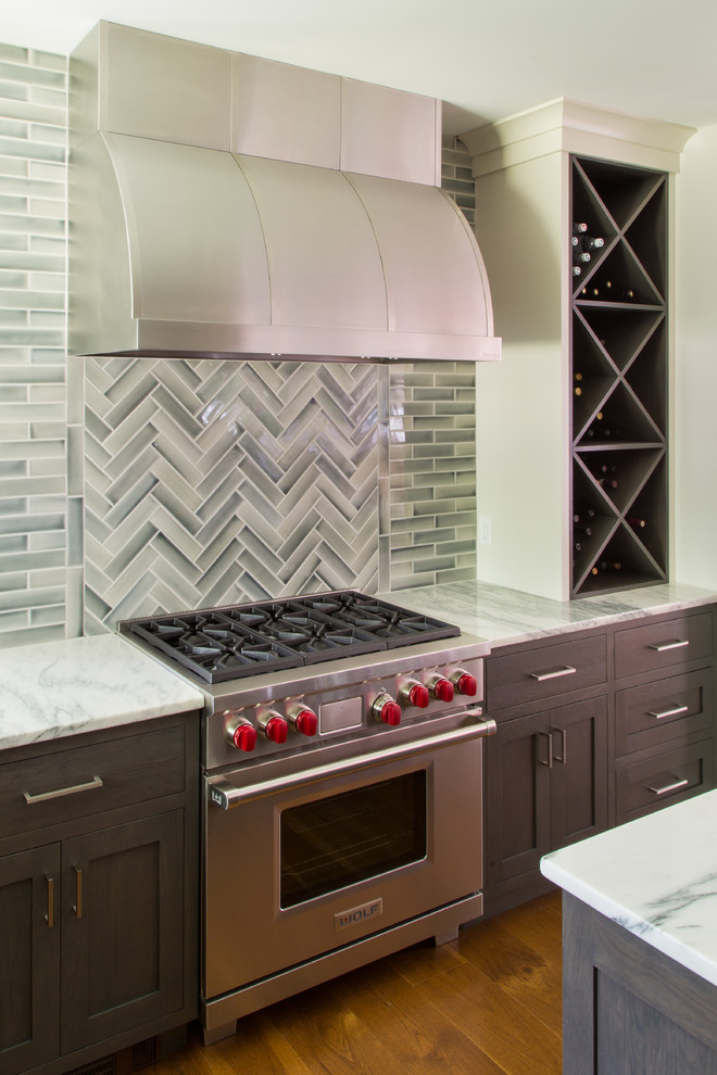 Inspiration för mellanstora moderna vitt kök, med en undermonterad diskho, luckor med infälld panel, vita skåp, marmorbänkskiva, rostfria vitvaror, mellanmörkt trägolv, en köksö, brunt golv, grått stänkskydd och stänkskydd i keramik