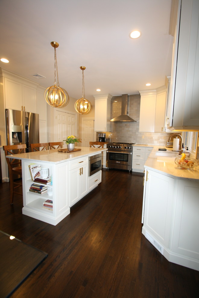 Eat-in kitchen - large transitional u-shaped dark wood floor and brown floor eat-in kitchen idea in New York with an undermount sink, recessed-panel cabinets, white cabinets, quartz countertops, beige backsplash, subway tile backsplash, stainless steel appliances, an island and multicolored countertops