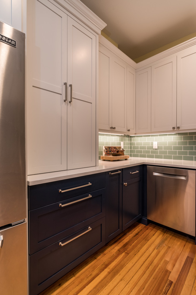Mid-sized arts and crafts u-shaped medium tone wood floor and brown floor eat-in kitchen photo in Denver with a farmhouse sink, shaker cabinets, white cabinets, quartz countertops, multicolored backsplash, glass tile backsplash, stainless steel appliances, a peninsula and white countertops