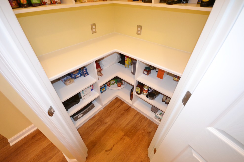 Inspiration for a large classic l-shaped kitchen pantry in Philadelphia with a submerged sink, raised-panel cabinets, medium wood cabinets, engineered stone countertops, stainless steel appliances, lino flooring, an island and beige floors.