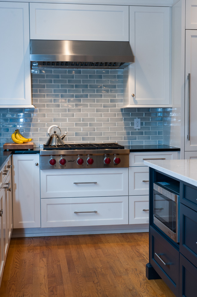 フィラデルフィアにあるトランジショナルスタイルのおしゃれなアイランドキッチン (落し込みパネル扉のキャビネット、パネルと同色の調理設備、無垢フローリング) の写真