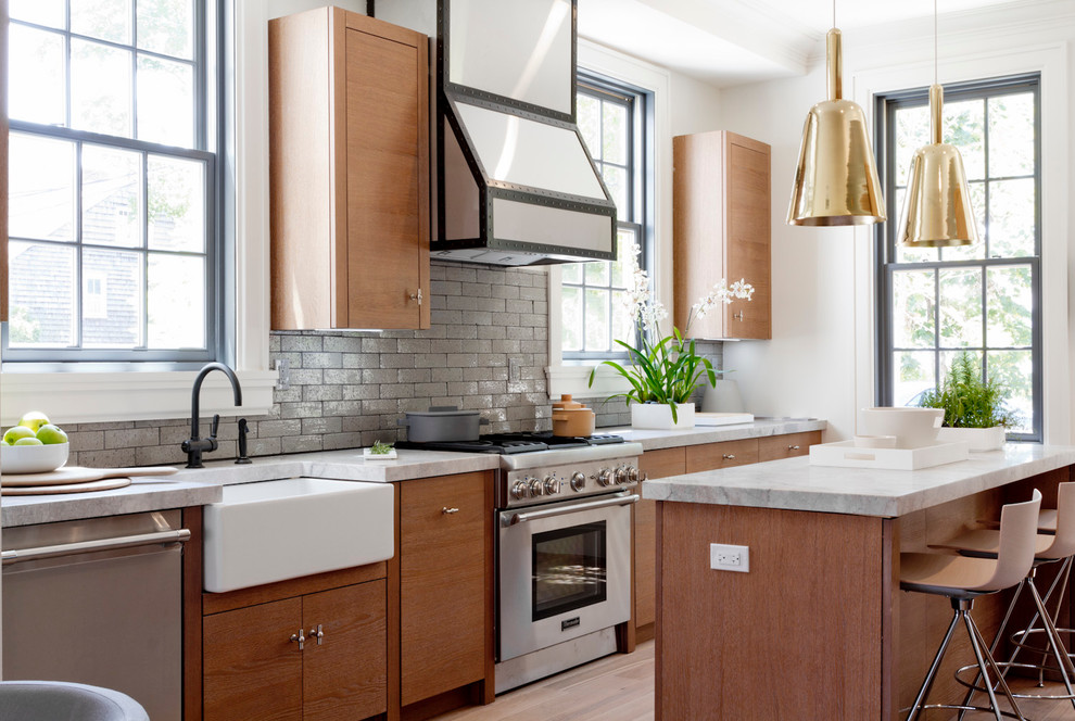 Moderne Küche mit Landhausspüle, flächenbündigen Schrankfronten, hellbraunen Holzschränken, Küchenrückwand in Grau, Küchengeräten aus Edelstahl, hellem Holzboden und Kücheninsel in New York