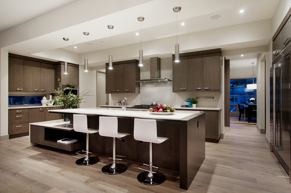 Example of a trendy light wood floor kitchen design in Calgary with stainless steel appliances, an undermount sink, flat-panel cabinets, dark wood cabinets, quartzite countertops, white backsplash, an island and glass sheet backsplash
