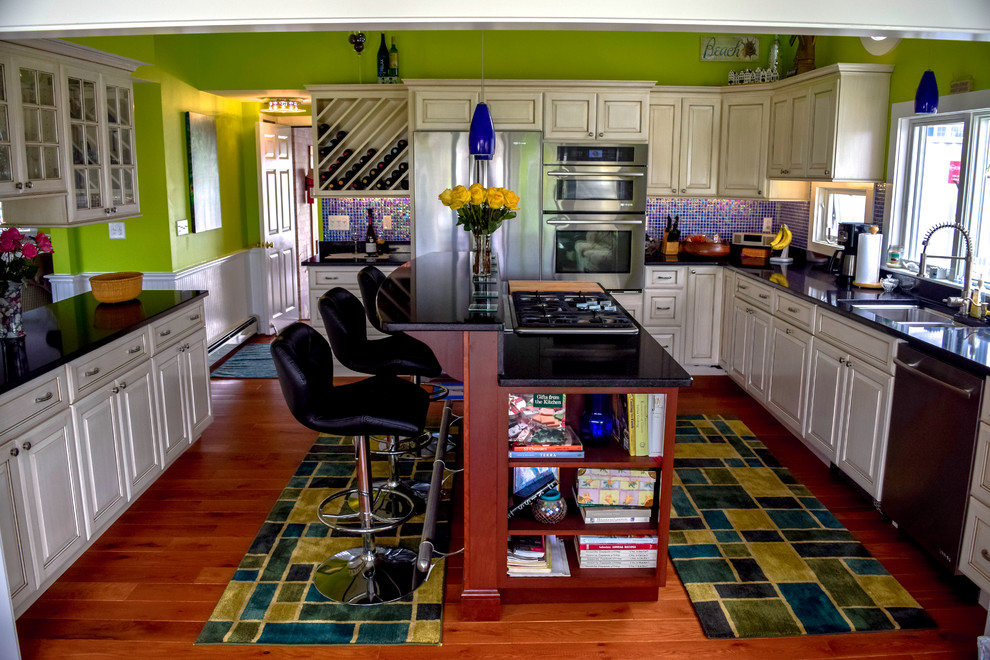 ボストンにある中くらいなエクレクティックスタイルのおしゃれなキッチン (白いキャビネット、メタリックのキッチンパネル、モザイクタイルのキッチンパネル、シルバーの調理設備、淡色無垢フローリング) の写真