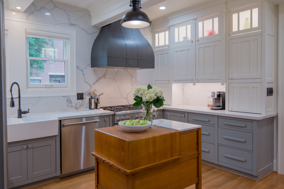 Foto på ett avskilt, litet amerikanskt u-kök, med en rustik diskho, skåp i shakerstil, grå skåp, bänkskiva i kvartsit, vitt stänkskydd, stänkskydd i marmor, rostfria vitvaror, mellanmörkt trägolv, en köksö och brunt golv