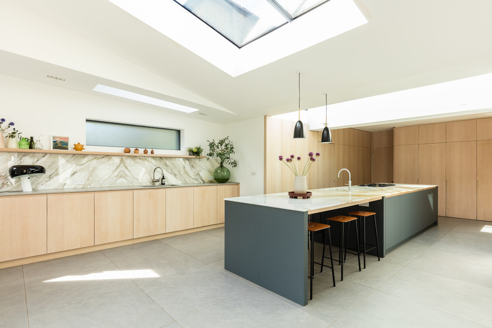 Moderne Küche in L-Form mit flächenbündigen Schrankfronten, hellen Holzschränken, Kücheninsel, grauem Boden und beiger Arbeitsplatte in London