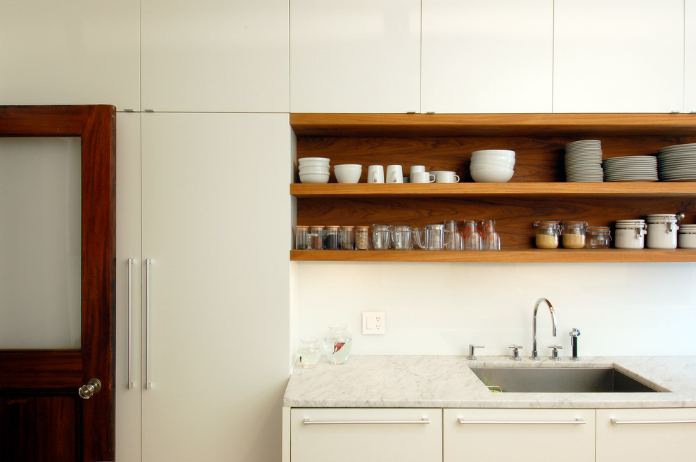 Cette image montre une cuisine design avec un évier 1 bac, un placard sans porte et des portes de placard beiges.