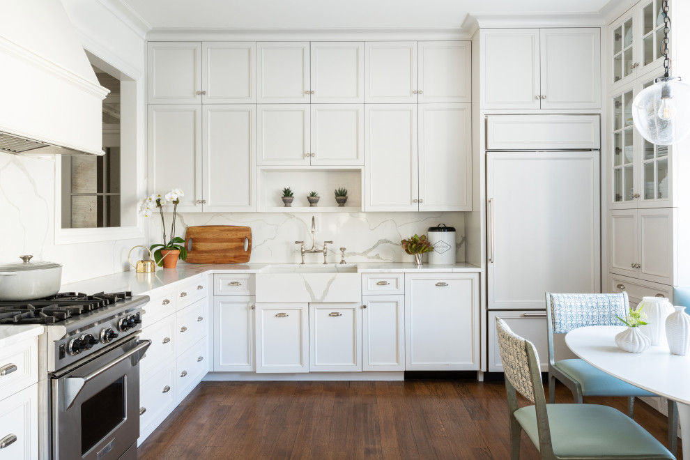 Transitional l-shaped dark wood floor and brown floor eat-in kitchen photo in New York with a farmhouse sink, recessed-panel cabinets, white cabinets, white backsplash, stone slab backsplash, paneled appliances, no island and white countertops