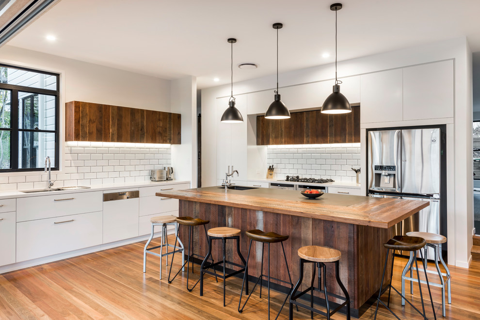 Mittelgroße Moderne Wohnküche in L-Form mit hellbraunen Holzschränken, Rückwand aus Keramikfliesen, hellem Holzboden und Kücheninsel in Brisbane