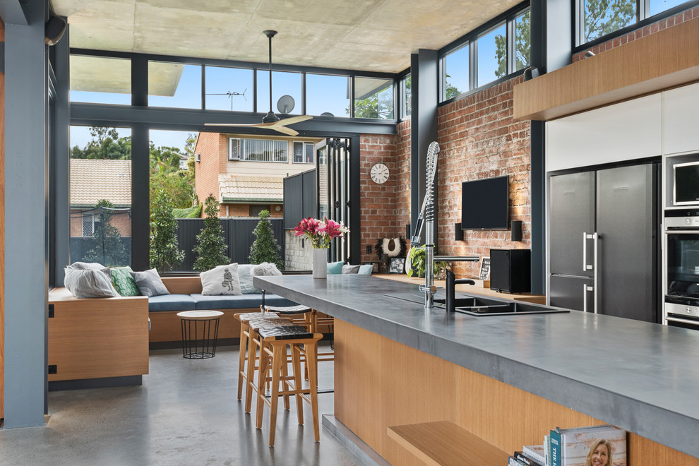Expansive urban galley open plan kitchen in Brisbane with concrete worktops, concrete flooring, an island and grey worktops.