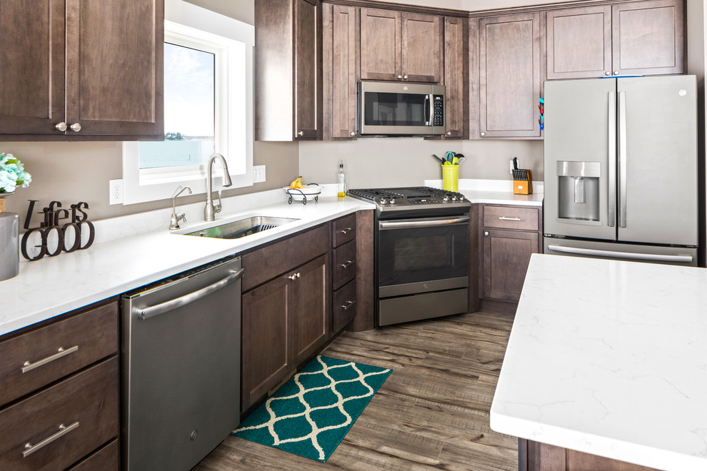 Mid-sized transitional l-shaped light wood floor and brown floor eat-in kitchen photo in Other with an undermount sink, shaker cabinets, medium tone wood cabinets, quartz countertops, white backsplash, stone slab backsplash, stainless steel appliances, an island and white countertops