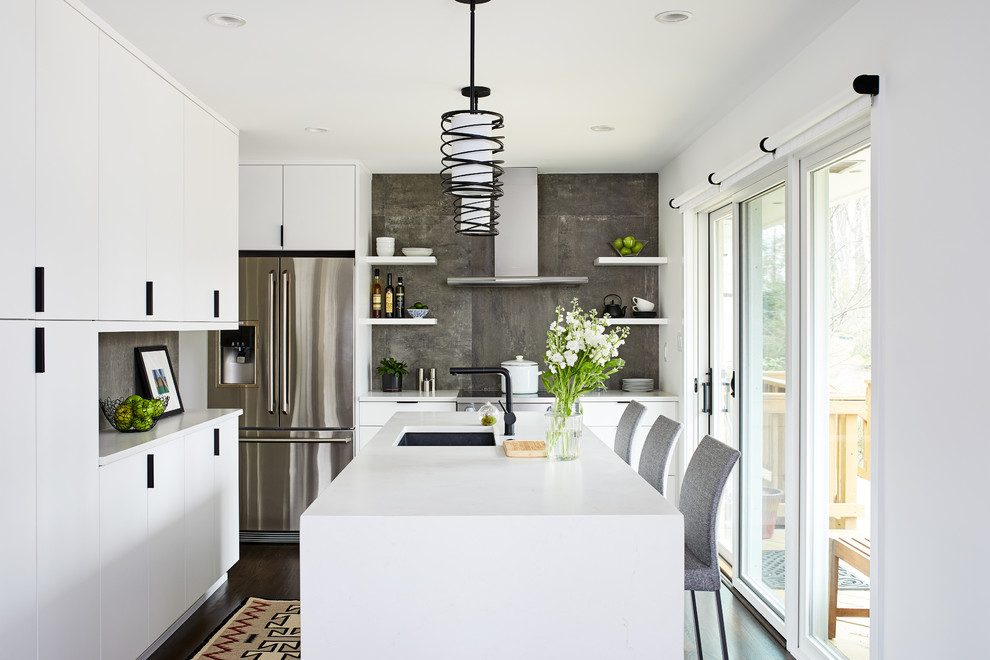 Exempel på ett avskilt, litet modernt vit vitt l-kök, med en undermonterad diskho, släta luckor, vita skåp, bänkskiva i kvarts, grått stänkskydd, stänkskydd i porslinskakel, rostfria vitvaror, mörkt trägolv, en köksö och brunt golv