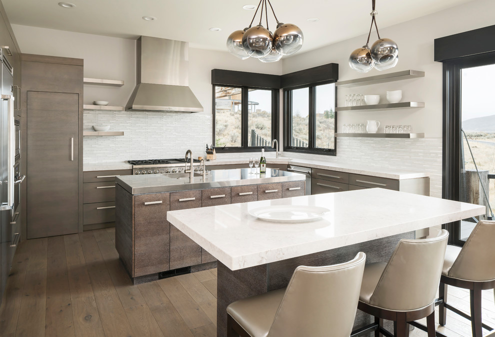 Inspiration for a rustic medium tone wood floor kitchen remodel in Salt Lake City with a single-bowl sink, flat-panel cabinets, medium tone wood cabinets, white backsplash, stainless steel appliances, two islands and white countertops