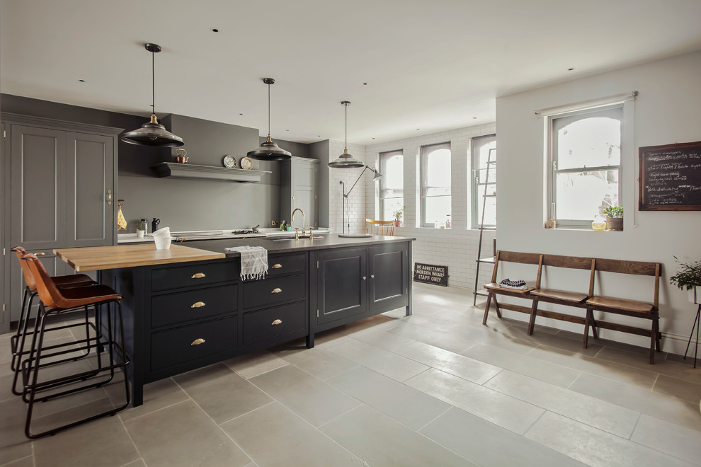 Klassische Küche mit Schrankfronten mit vertiefter Füllung, grauen Schränken, Küchenrückwand in Grau und Kücheninsel in London
