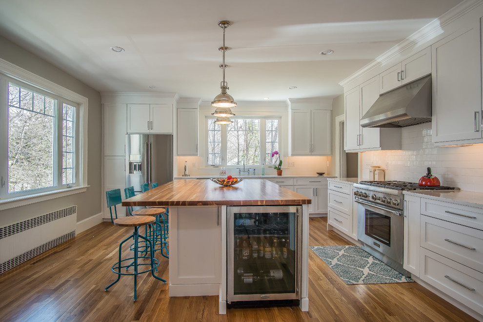Eat-in kitchen - large cottage l-shaped medium tone wood floor and green floor eat-in kitchen idea in Bridgeport with an undermount sink, shaker cabinets, white cabinets, quartz countertops, white backsplash, subway tile backsplash, stainless steel appliances and an island