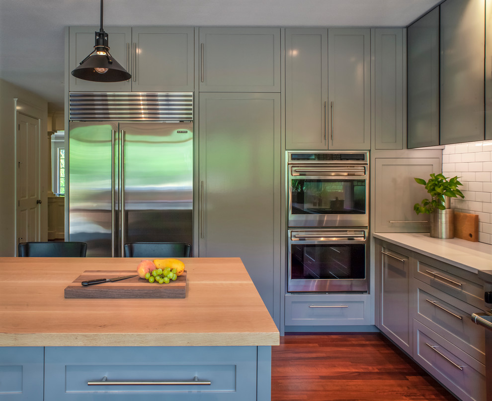 Inspiration for a transitional medium tone wood floor eat-in kitchen remodel in Portland with shaker cabinets, gray cabinets, quartz countertops, white backsplash, subway tile backsplash, stainless steel appliances, an island and white countertops