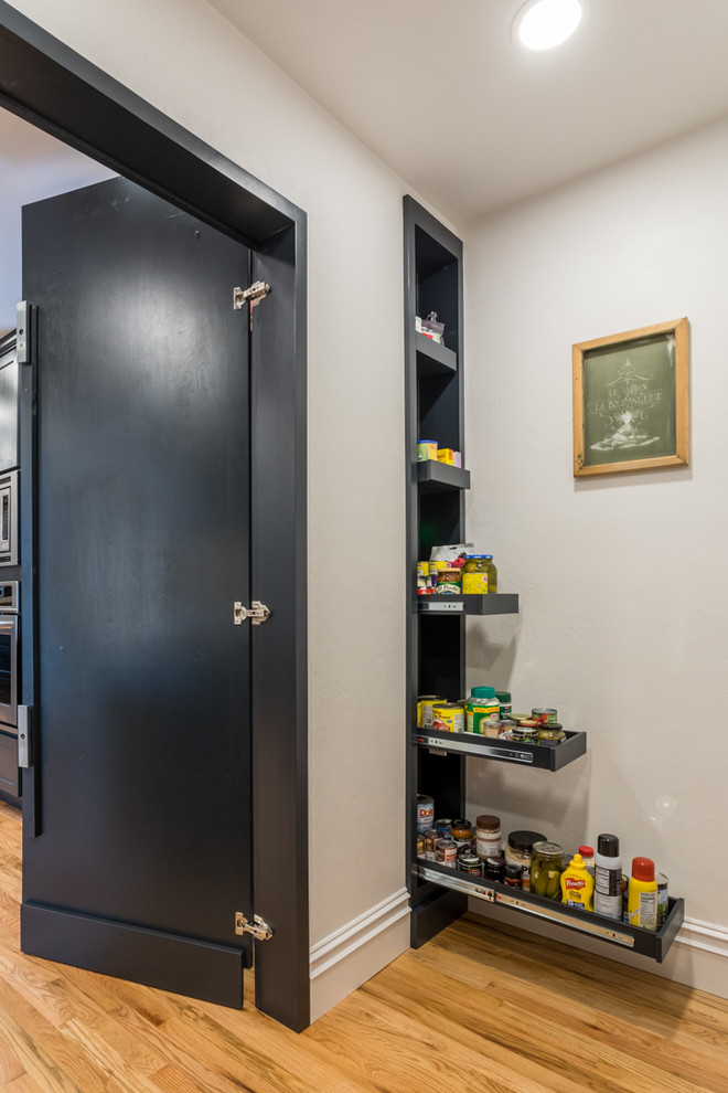 Medium sized modern kitchen pantry in Portland with shaker cabinets, black cabinets, marble worktops, white splashback, marble splashback, light hardwood flooring and white worktops.