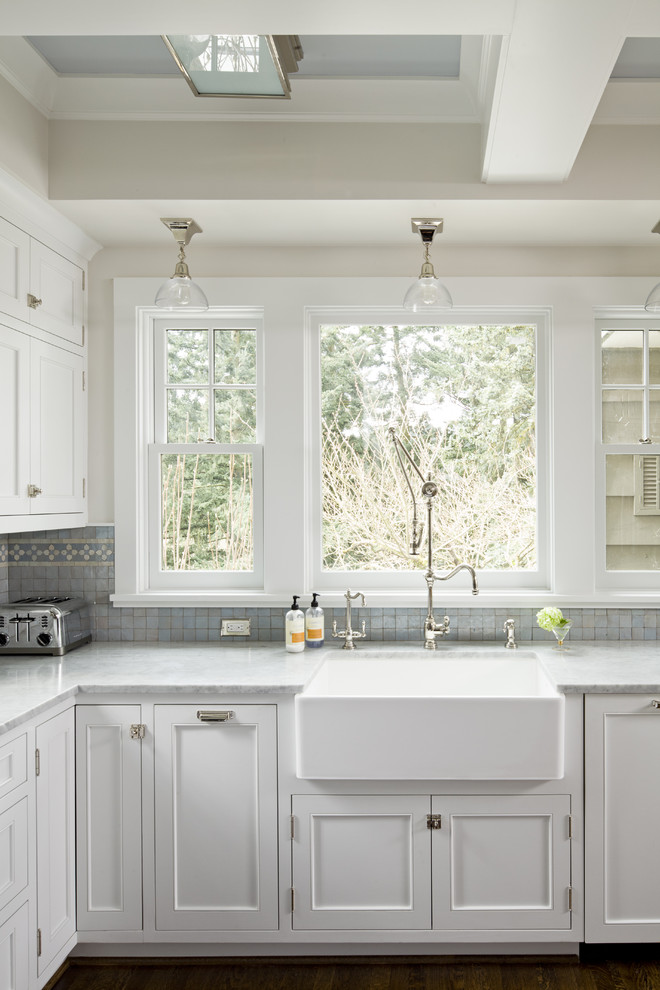 Klassische Küche mit Landhausspüle, Schrankfronten mit vertiefter Füllung, weißen Schränken, Marmor-Arbeitsplatte und Küchenrückwand in Blau in Portland