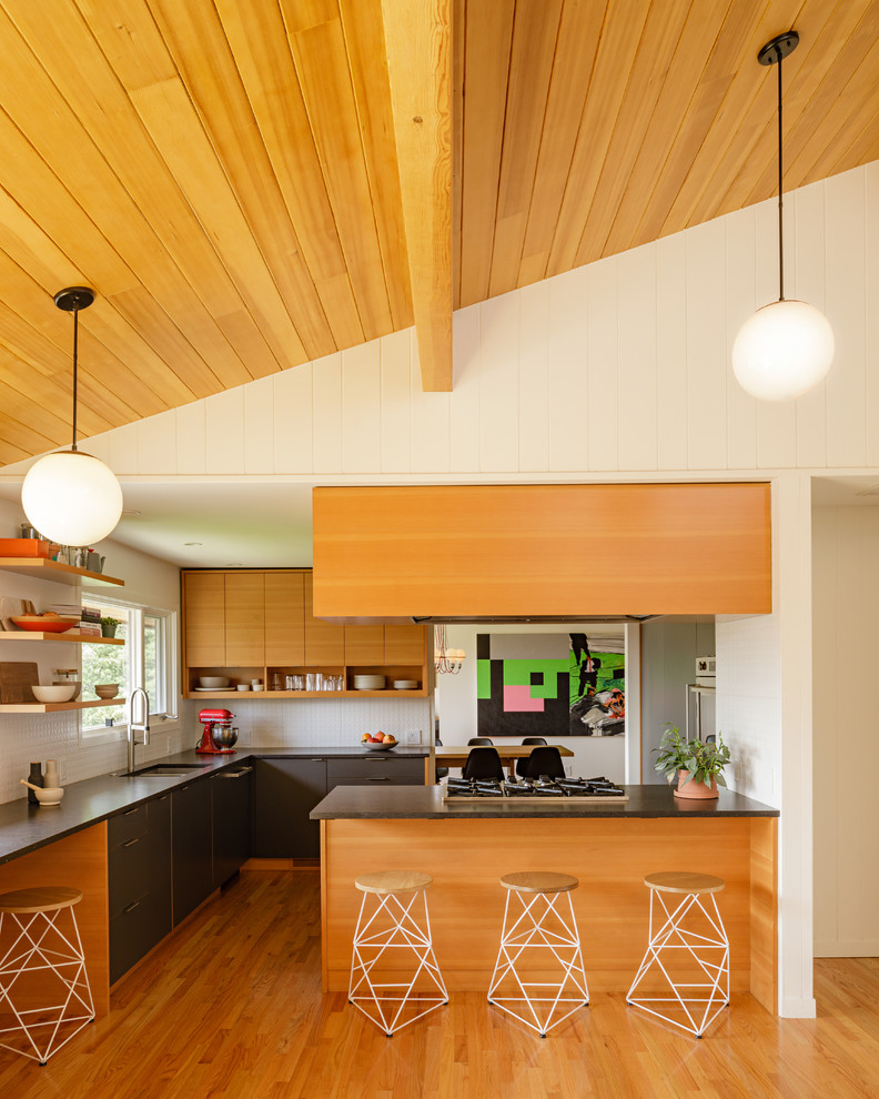 Retro Küche mit Doppelwaschbecken, flächenbündigen Schrankfronten, grauen Schränken, braunem Holzboden, Halbinsel und grauer Arbeitsplatte in Portland