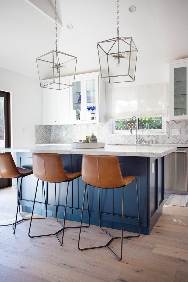Klassische Küche mit Schrankfronten im Shaker-Stil, blauen Schränken, Küchenrückwand in Grau, Küchengeräten aus Edelstahl, hellem Holzboden, Kücheninsel und beigem Boden in Los Angeles