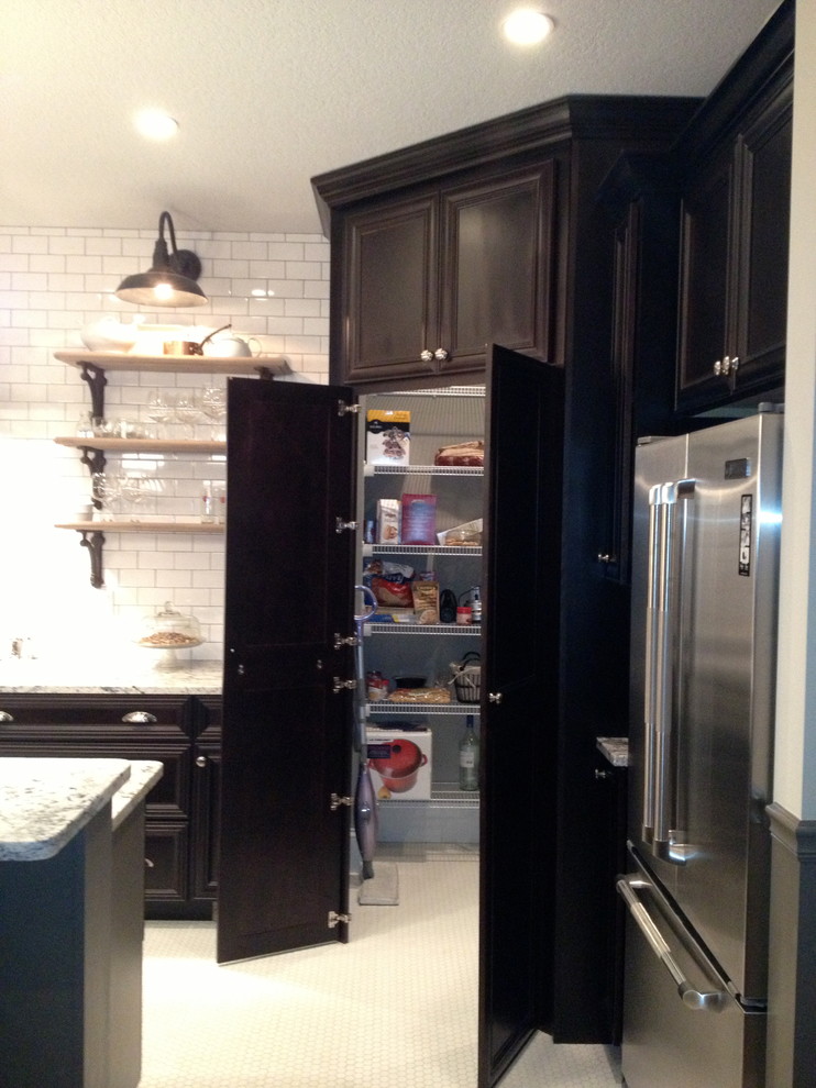 Bild på ett mellanstort vintage kök, med skåp i shakerstil, svarta skåp, marmorbänkskiva, vitt stänkskydd, stänkskydd i tunnelbanekakel, rostfria vitvaror, klinkergolv i porslin och en köksö