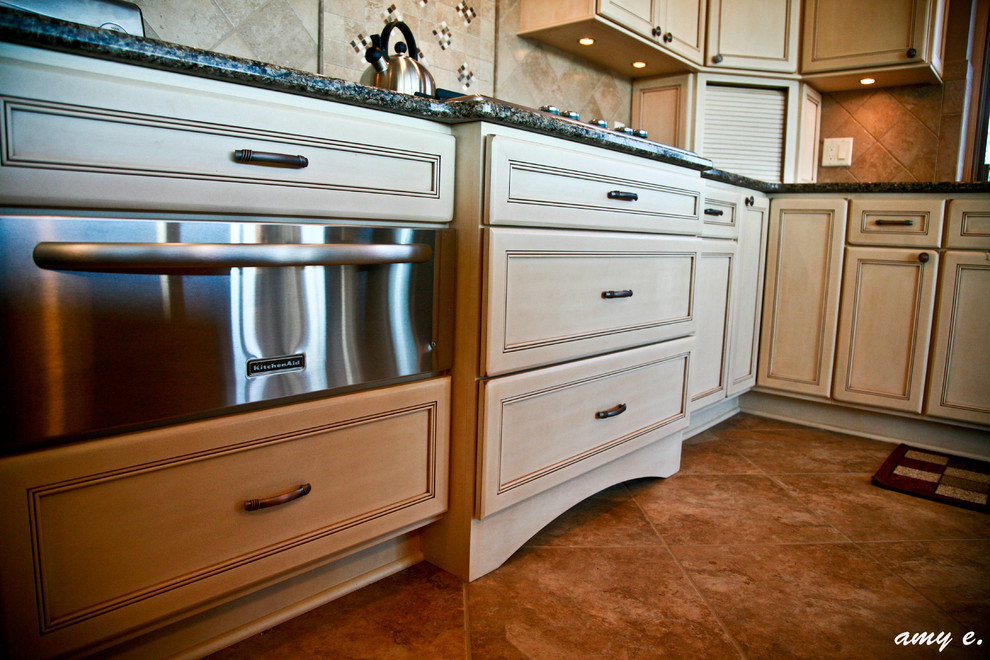 Example of a large classic l-shaped ceramic tile enclosed kitchen design in Other with an undermount sink, recessed-panel cabinets, light wood cabinets, quartz countertops, beige backsplash, stainless steel appliances, ceramic backsplash and an island