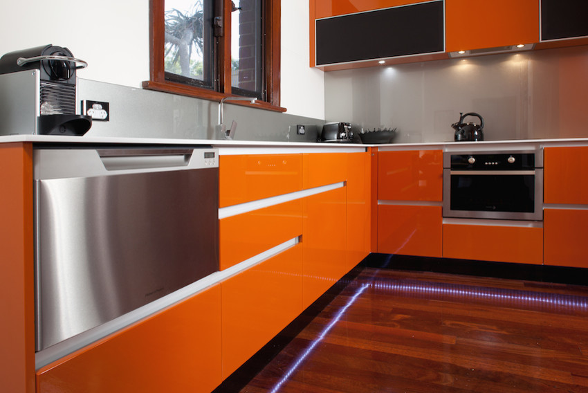 Idéer för ett mellanstort modernt grå kök, med en integrerad diskho, släta luckor, orange skåp, bänkskiva i koppar, stänkskydd med metallisk yta, glaspanel som stänkskydd, rostfria vitvaror och mörkt trägolv