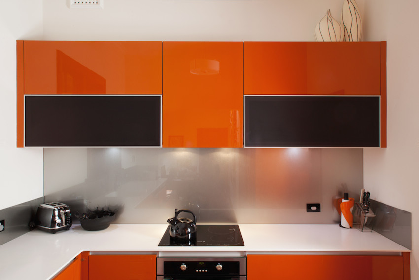 Exempel på ett mellanstort modernt grå grått kök, med en integrerad diskho, släta luckor, orange skåp, bänkskiva i koppar, stänkskydd med metallisk yta, glaspanel som stänkskydd, rostfria vitvaror och mörkt trägolv