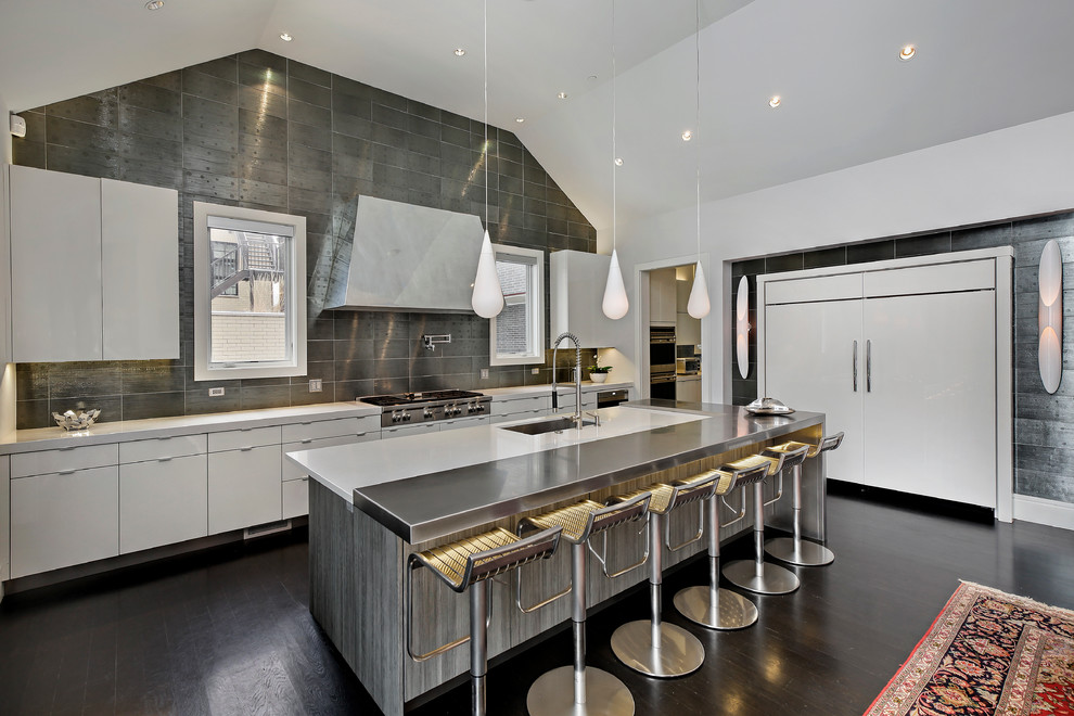 Moderne Küche mit Unterbauwaschbecken, flächenbündigen Schrankfronten, weißen Schränken, Küchenrückwand in Metallic, Küchengeräten aus Edelstahl, dunklem Holzboden und Kücheninsel in Chicago