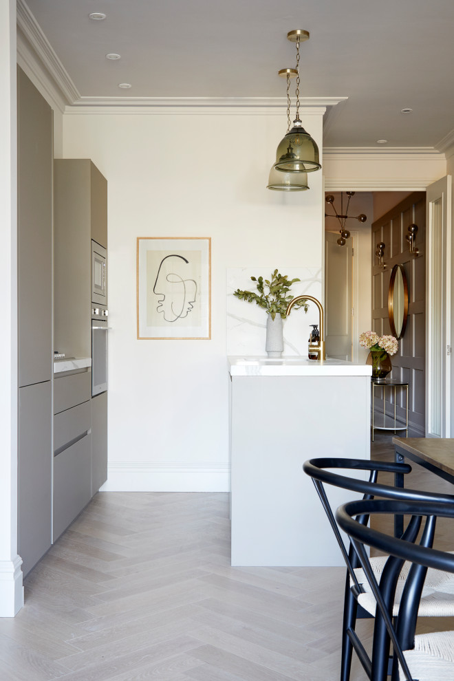 Diseño de cocina contemporánea con armarios con paneles lisos, puertas de armario grises, electrodomésticos de acero inoxidable, península, suelo gris y encimeras blancas