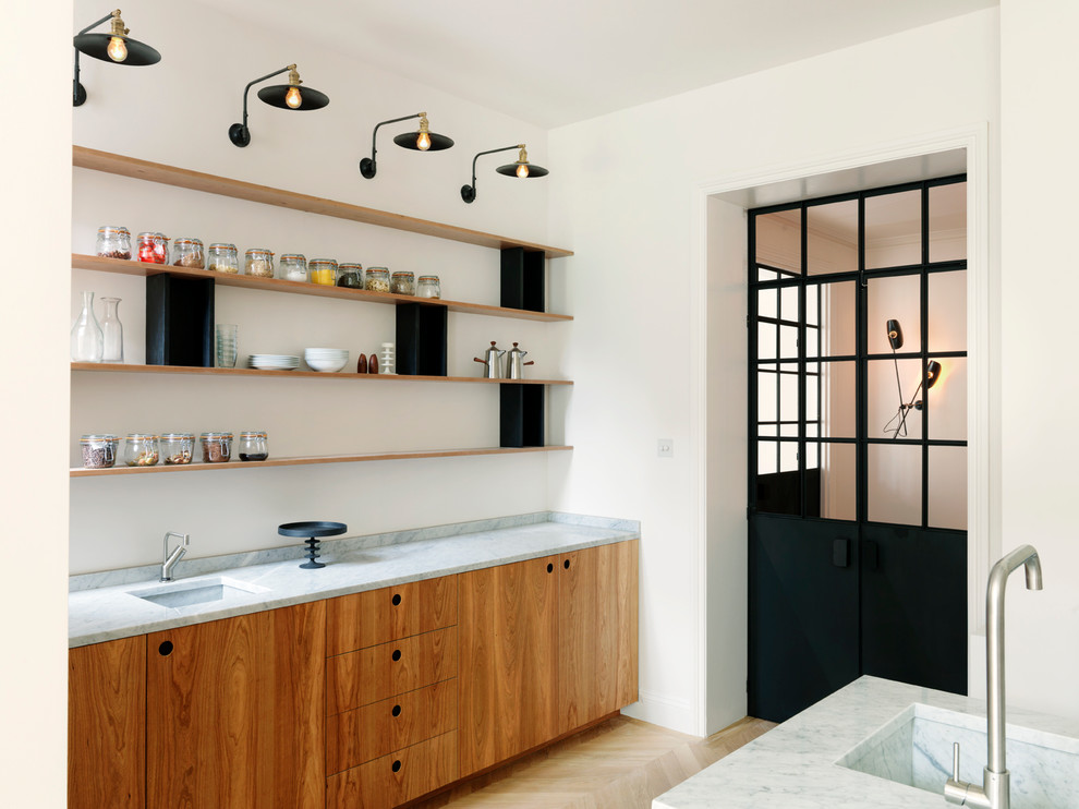 Idée de décoration pour une cuisine design en bois brun avec un évier encastré, un placard à porte plane et parquet clair.