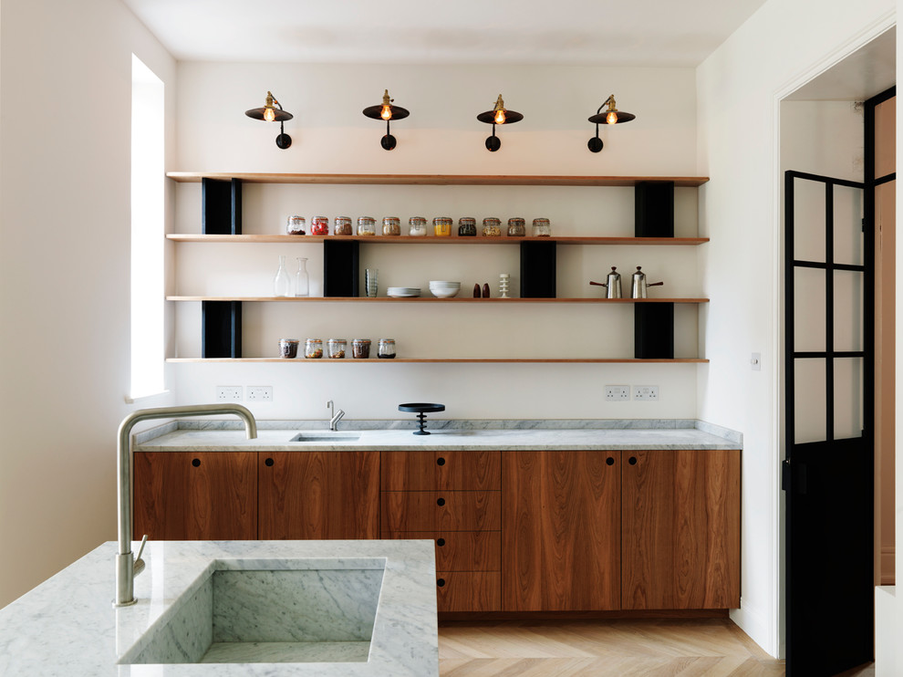 Foto de cocina actual con fregadero bajoencimera, armarios con paneles lisos, puertas de armario de madera en tonos medios y salpicadero blanco
