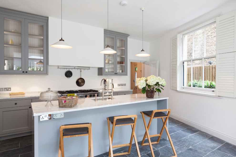 Klassische Küche mit grauen Schränken, Marmor-Arbeitsplatte, Kücheninsel, Unterbauwaschbecken und Glasfronten in Oxfordshire