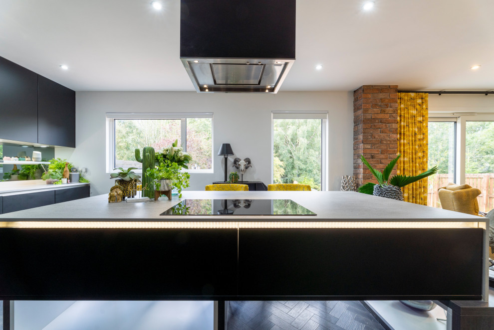 Exempel på ett mellanstort modernt flerfärgad flerfärgat kök, med en nedsänkt diskho, släta luckor, svarta skåp, bänkskiva i koppar, grått stänkskydd, spegel som stänkskydd, svarta vitvaror, mörkt trägolv, en köksö och svart golv