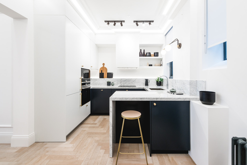 Inspiration for a small contemporary u-shaped kitchen in London with flat-panel cabinets, marble worktops, marble splashback, stainless steel appliances, light hardwood flooring, a breakfast bar, beige floors, grey worktops, a submerged sink, black cabinets and grey splashback.