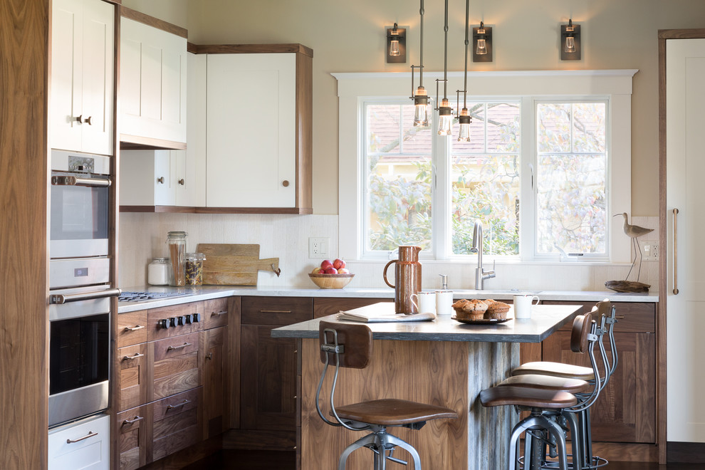 Immagine di una cucina country con lavello sottopiano, ante in stile shaker, ante in legno bruno, elettrodomestici in acciaio inossidabile, parquet scuro e pavimento marrone
