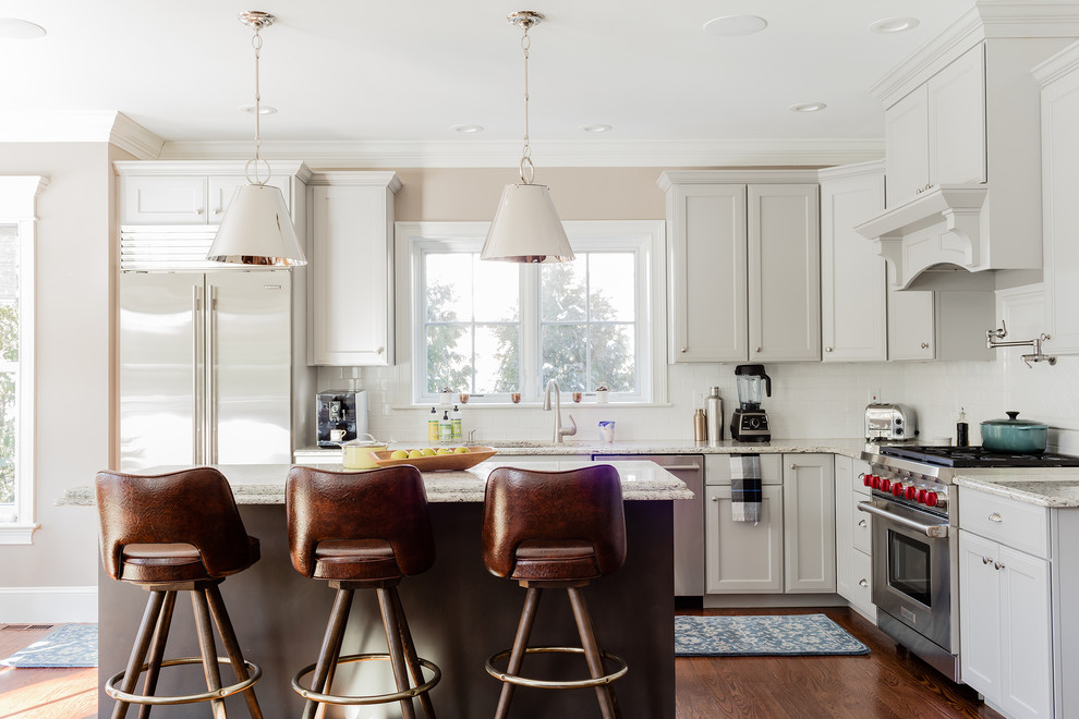 Mittelgroße Klassische Küche in L-Form mit Schrankfronten mit vertiefter Füllung, grauen Schränken, Rückwand-Fenster, Küchengeräten aus Edelstahl, braunem Holzboden und Kücheninsel in Boston