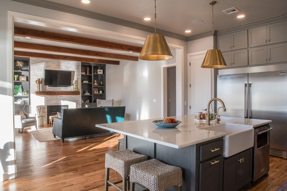 Inspiration for a large transitional galley medium tone wood floor and brown floor open concept kitchen remodel in Oklahoma City with a farmhouse sink, shaker cabinets, gray cabinets, marble countertops, white backsplash, ceramic backsplash, stainless steel appliances and an island