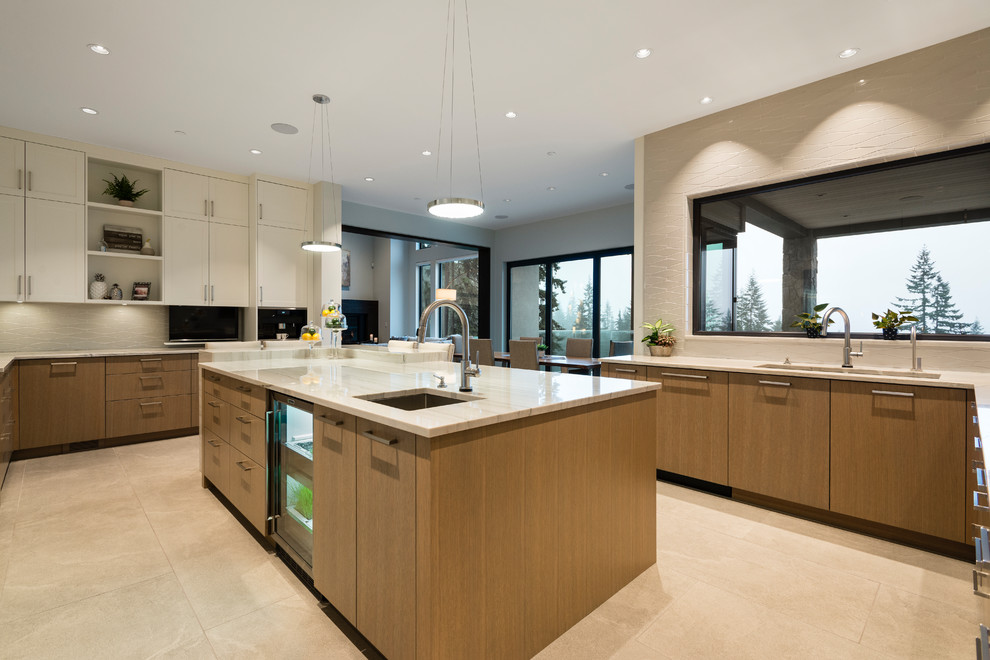 Example of a huge transitional u-shaped porcelain tile and gray floor open concept kitchen design in Vancouver with an undermount sink, flat-panel cabinets, light wood cabinets, granite countertops, white backsplash, porcelain backsplash, stainless steel appliances, an island and white countertops
