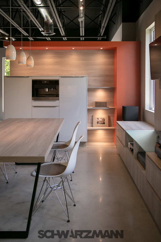 Foto de cocinas en L moderna de tamaño medio abierta con fregadero bajoencimera, armarios con paneles lisos, puertas de armario amarillas, encimera de cuarzo compacto, salpicadero naranja, salpicadero de losas de piedra, electrodomésticos de acero inoxidable, suelo de cemento y península