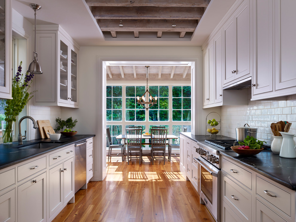Imagen de cocina clásica cerrada con armarios con rebordes decorativos, electrodomésticos de acero inoxidable y encimera de esteatita