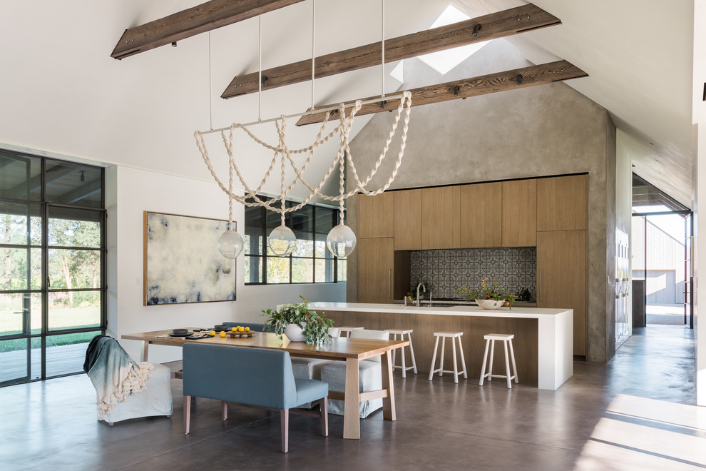 This is an example of a farmhouse galley open plan kitchen in San Francisco with flat-panel cabinets, medium wood cabinets, multi-coloured splashback, integrated appliances, concrete flooring, an island, grey floors and white worktops.