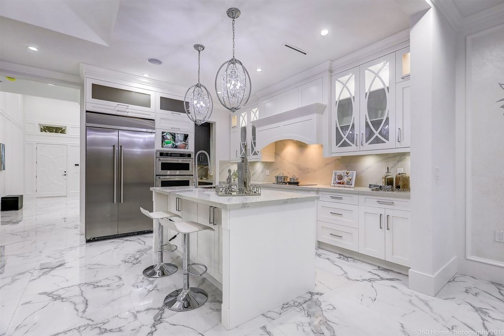 Foto på ett mellanstort vintage vit kök, med en undermonterad diskho, skåp i shakerstil, vita skåp, marmorbänkskiva, vitt stänkskydd, stänkskydd i marmor, rostfria vitvaror, marmorgolv, en köksö och vitt golv