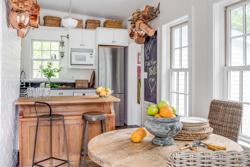 Inspiration for a small shabby-chic style u-shaped medium tone wood floor and brown floor eat-in kitchen remodel in Boston with an undermount sink, shaker cabinets, white cabinets, soapstone countertops, white backsplash, cement tile backsplash, stainless steel appliances and a peninsula
